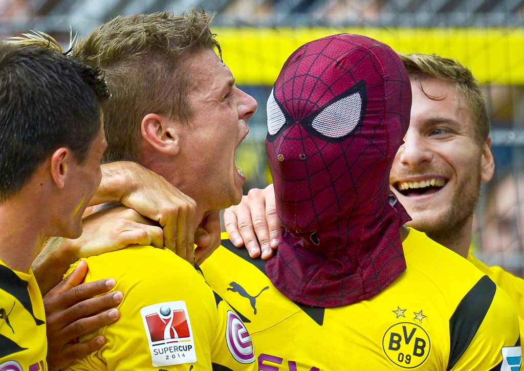 Dortmund's Pierre-Emerick Aubameyang, right, wears a Spiderman mask as he celebrates after scoring his side's second goal during the German soccer Super Cup match between Borussia Dortmund and Bayern Munich in Dortmund, Germany, Wednesday, Aug. 13, 2014. (AP Photo/Sascha Schuermann)